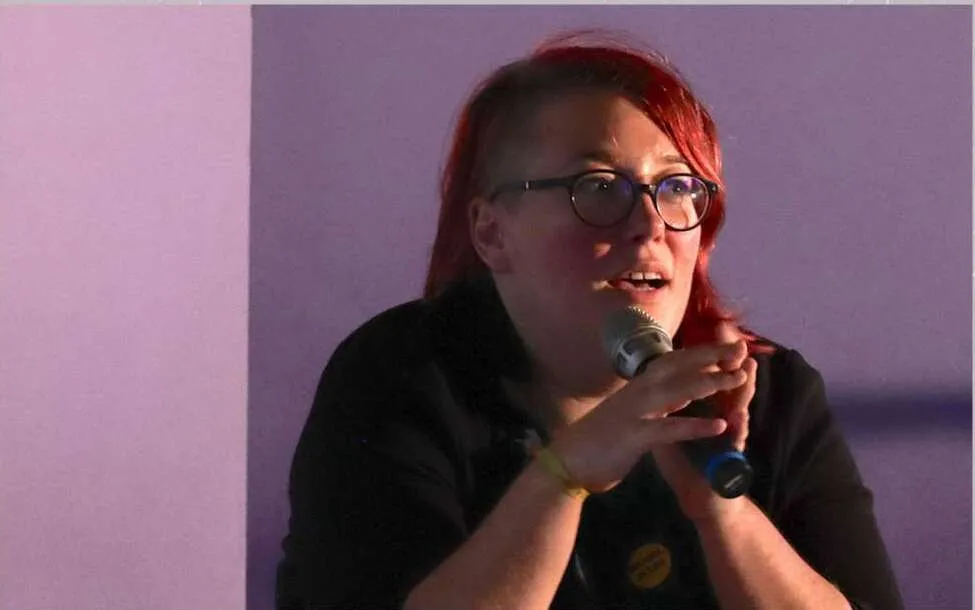 Emi au micro pendant la conférence gesticulée Rébellion d'une CPE