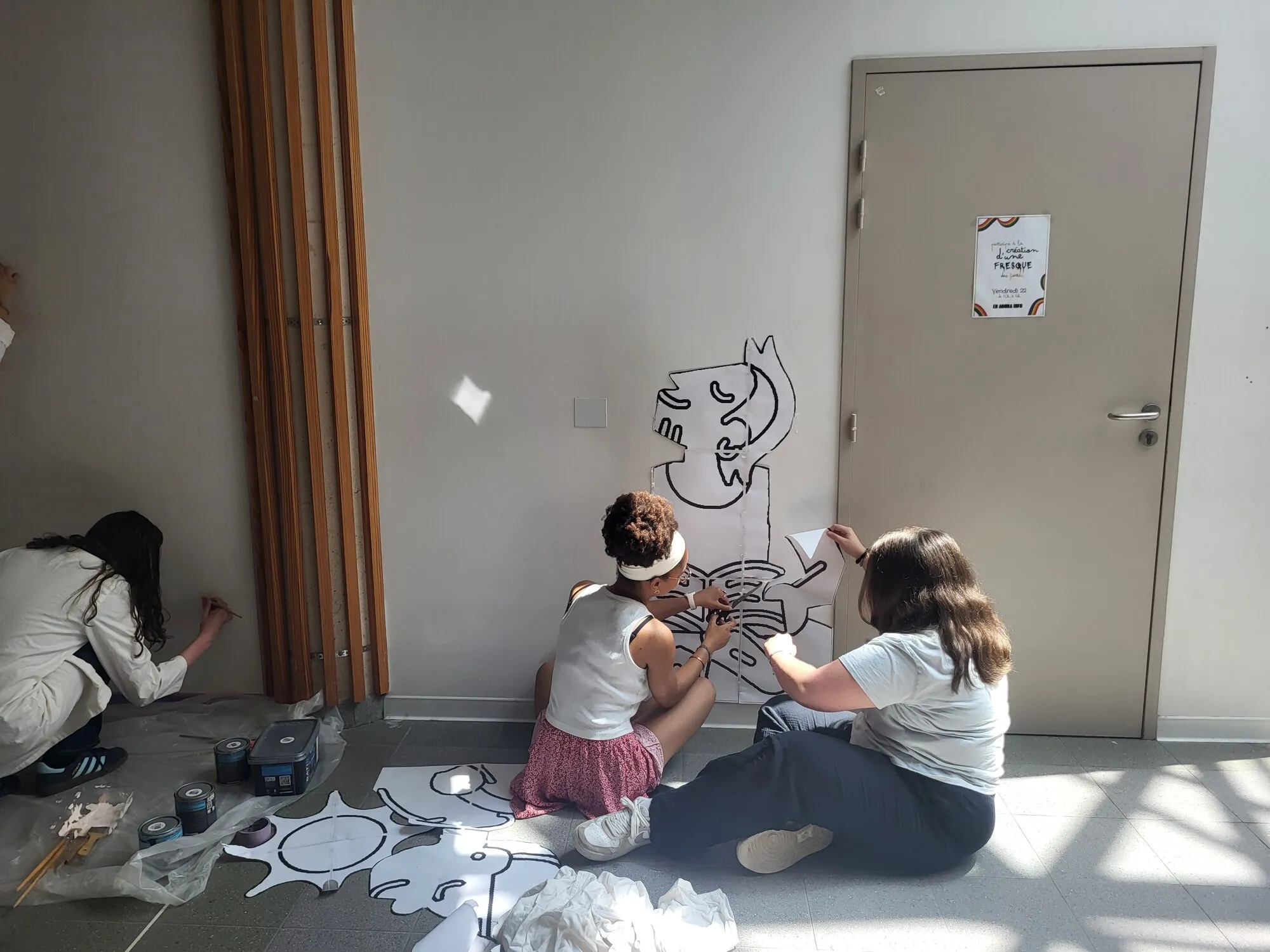 Des élèves préparent une fresque collective sur un mur d'établissement